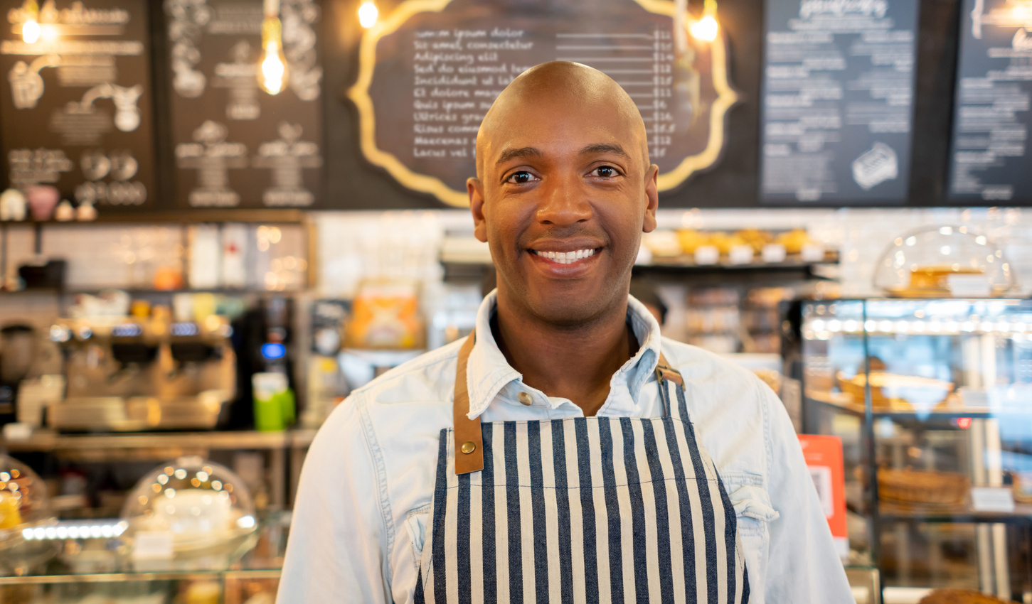 Happy African American business owner working at a restaurant